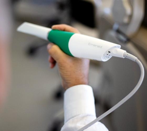 Pediatric dentist holding an advanced dental scanner