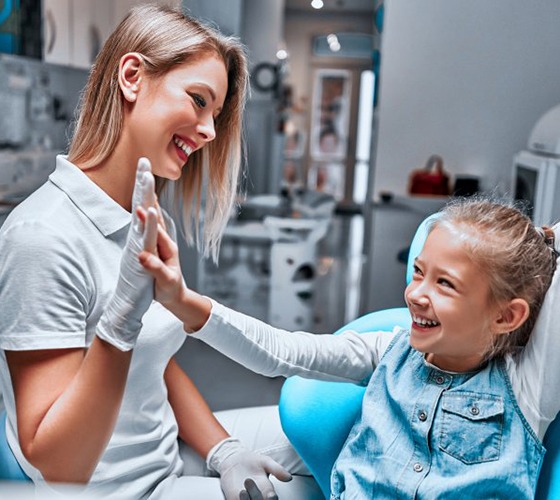 Little girl high-fiving dentist after treatment