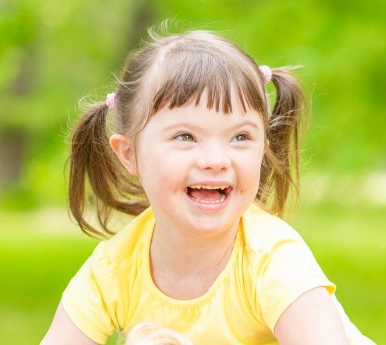 Young girl with special needs smiling outdoors