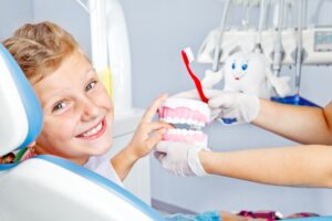 Smiling young girl in dentist’s chair